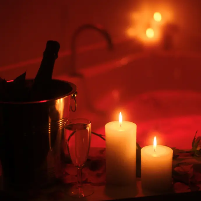 Een romantische kamer met champagne, kaarsen en een bubbelbad